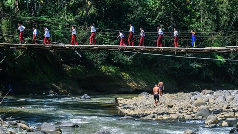 Siswa Sekolah Dasar (SD) menyeberangi Jembatan Gantung Lengkongjaya yang melintasi Sungai Ciwulan, Desa Pusparaja, Kabupaten Tasikmalaya, Jawa Barat, Selasa (23/7/2019). Foto: ANTARA FOTO/Adeng Bustomi