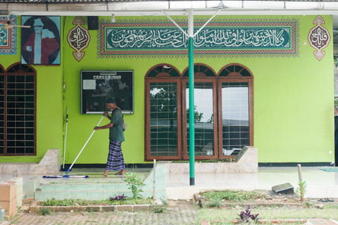 Penjaga membersihkan area makam Habib Kuncung di Kalibata.   Foto: Iqbal Firdaus/kumparan