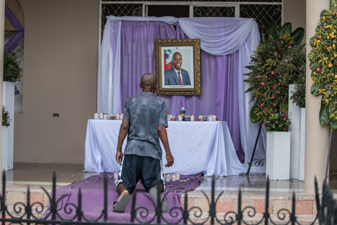 Seorang pria berdoa di depan tugu peringatan untuk Presiden Jovenel Moise yang dipasang di dekat Katedral Our Lady of the Assumption di Cap-Haitien. Foto: Valerie Baeriswyl / AFP