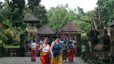 Turis mengenakan sarung saat berkunjung ke Pura Tirta Empul di Bali Foto: Helinsa Rasputri/kumparan