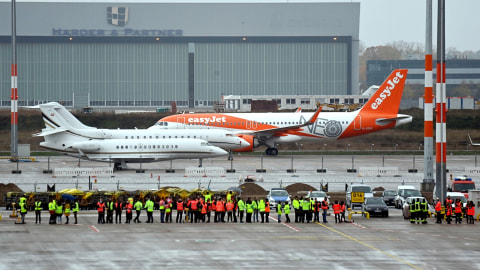 Staff melihat pesawat Lufthansa dan pesawat EasyJet usai mendarat, menandai pembukaan resmi Bandara Berlin-Brandenburg (BER) "Willy Brandt", di Schoenefeld dekat Berlin, Jerman, Sabtu (31/10). Foto: Fabrizio Bensch/REUTERS