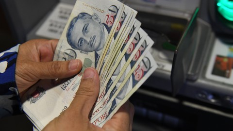 Ilustrasi uang dolar Singapura Foto: AFP/Roslan Rahman