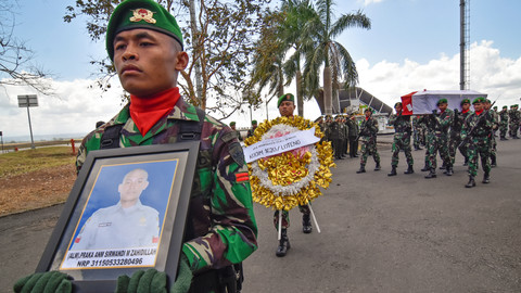 Anggota TNI mengusung peti jenazah Praka Anumerta Sirwandi M. Sahidillah yang tiba di Lombok International Airport di Praya, Lombok Tengah, NTB, Senin (19/8). Foto: ANTARA FOTO/Ahmad Subaidi