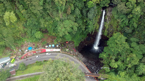 Kendaraan melintas di depan objek wisata air terjun Lembah Anai, di Tanah Datar, Sumatera Barat. Foto: ANTARA FOTO/Iggoy el Fitra