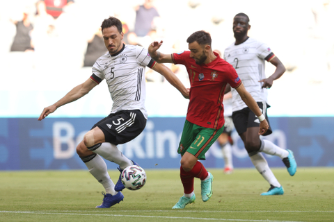 Pemain Portugal Bruno Fernandes berebut bola dengan pemain Jerman Mats Hummels pada pertandingan lanjutan Grup F Euro 2020 di Allianz Arena, Muenchen, Jerman. Foto: Alexander Hassenstein/Pool/REUTERS