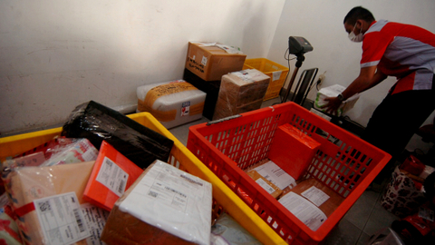 Pekerja menimbang paket untuk dikirim ke alamat tujuan di JNE Tegal, Jawa Tengah, Kamis (15/4/2021). Foto: Oky Lukmansyah/ANTARA FOTO