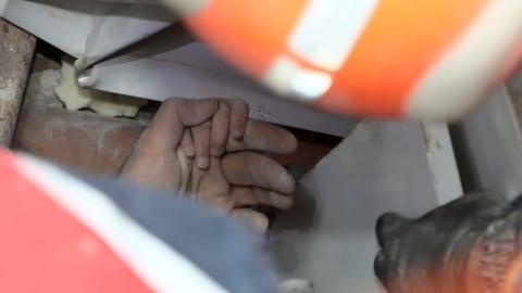 Korban gempa Ayda Gezgin memegang tangan seorang petugas penyelamat saat dia menunggu untuk diselamatkan dari gedung yang runtuh akibat gempa bumi di Izmir, Turki. Foto: AFAD/via REUTERS