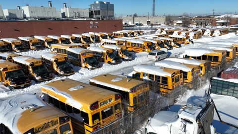 Sejumlah bus sekolah yang diselimuti salju terparkir di Stock Transportation di Scarborough, Ontario, Kanada, Selasa (18/1/2022). Foto: Chris Helgren/REUTERS