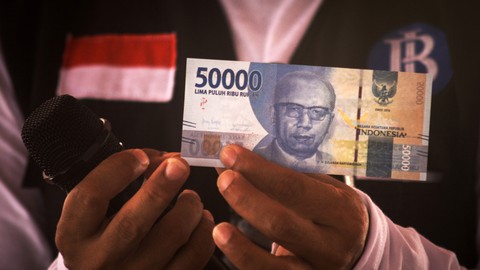Pegawai Bank Indonesia (BI) memperlihatkan uang rupiah pecahan lima puluh ribu saat sosialisasi cara mengidentifikasi uang palsu di Miangas, Kabupaten Talaud, Sulawesi Utara, (21/1/2022). Foto: Adwit B Pramono/Antara
