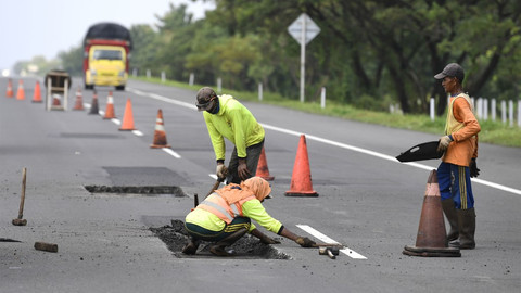 Pekerja menyelesaikan perbaikan jalan di Tol Brebes-Pejagan, Jawa Tengah, Minggu (12/5/19). Foto: ANTARA FOTO/Puspa Perwitasari