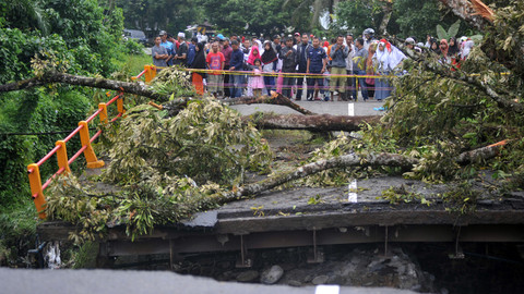 Sejumlah warga menyaksikan jembatan yang roboh di Jalan Raya Padang - Bukittinggi, Kayutanam, Sumatera Barat, Selasa (11/12/ Foto: ANTARA FOTO/Iggoy el Fitra