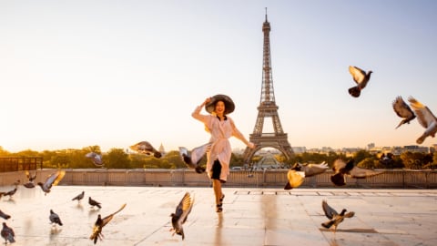 Ilustrasi seorang turis wanita berfoto di Menara Eiffel, Paris Foto: Shutter Stock