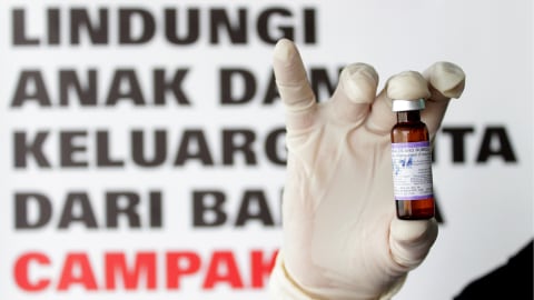 Petugas menunjukan Vaksin Campak dan Rubella (MR) sebelum melakukan imunisasi kepada anak. Foto: ANTARA FOTO/Ampelsa