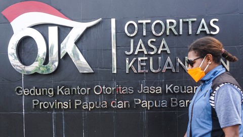 Seorang warga melintas di depan kantor Otoritas Jasa Keuangan (OJK). Foto: ANTARA FOTO/Indrayadi TH