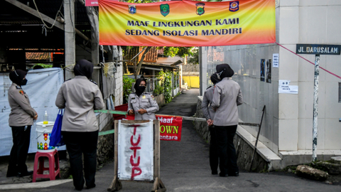Petugas Kepolisian berjaga kawasan yang sedang menerapkan lockdown skala mikro di Jalan As-Syafiiyah, Cipayung, Jakarta, Jumat (28/5/2021). Foto: Galih Pradipta/ANTARA FOTO