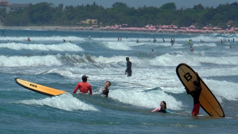 Wisatawan mancanegara bermain selancar di Pantai Kuta, Badung, Bali. Foto: ANTARA FOTO/Nyoman Hendra Wibowo
