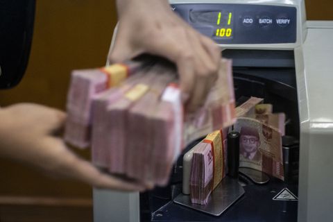 Petugas mengitung uang rupiah di salah satu gerai penukaran uang asing di Jakarta, Rabu (27/11). Foto: ANTARA FOTO/Aprillio Akbar