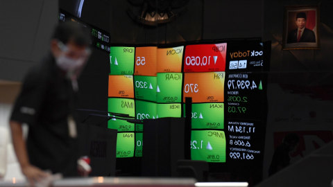 Petugas membersihkan area ruang utama berlatar layar pergerakan Indeks Harga Saham Gabungan (IHSG) di Bursa Efek Indonesia, Jakarta, Jumat (25/9). Foto: Puspa Perwitasari/ANTARA FOTO