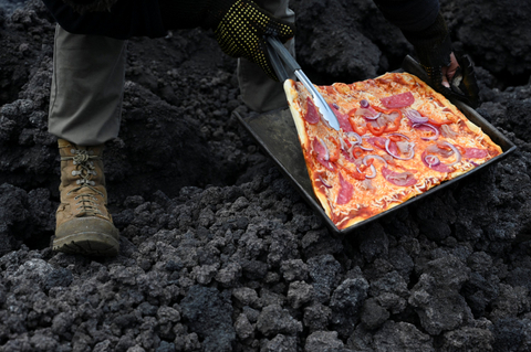 Chef David Garcia memeriksa pizza yang dia masak di sungai lava yang turun dari gunung berapi Pacaya di bukit Cerro Chino di kotamadya San Vicente Pacaya, Guatemala. Foto: Johan Ordonez/AFP
