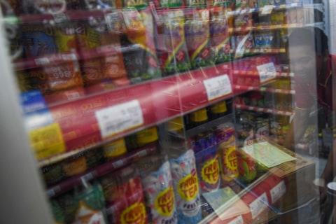 Karyawan melintas di depan lemari pendingin minuman kemasan di salah satu gerai Alfamart di Palembang, Sumatera Selatan, Kamis (20/2). Foto:  ANTARA FOTO/Nova Wahyud