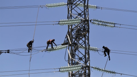 Pekerja memasang jaringan kabel ke tower milik PT PLN Persero yang akan dialiri listrik dari PLTU IPP 3 Kendari. Foto: ANTARA FOTO/Jojon