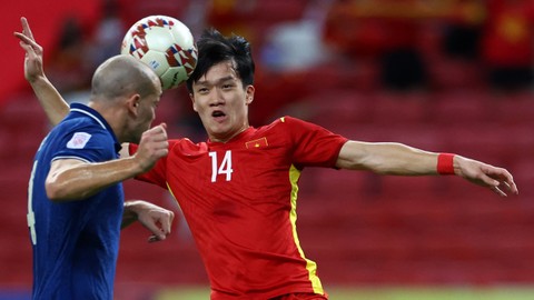 Pemain Vietnam Nguyen Hoang Duc berebut bola dengan pemain Thailand Manuel Tom Bihr pada semifinal Piala AFF Suzuki di Stadion Nasional Singapura, Kamis (23/12). Foto: Yong Teck Lim/Getty Images