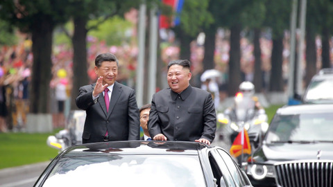 Pemimpin Korea Utara Kim Jong Un (kanan)  dan Presiden China Xi Jinping (kiri) menyapa warga selama pertemuan di Pyongyang, Korea Utara. Foto: Reuters/KCNA