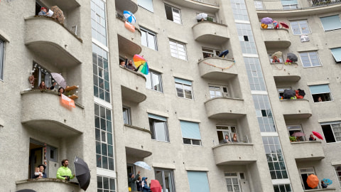 Penghuni gedung apartemen St-Jean ambil bagian dalam sesi paduan suara dari balkon mereka, di Jenewa, Swiss. Foto: REUTERS/Denis Balibouse