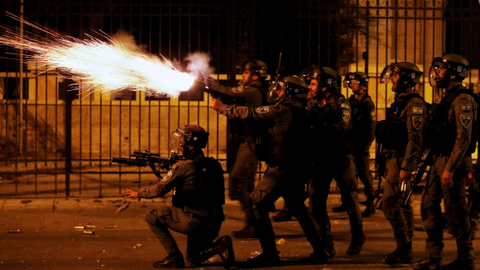Seorang anggota polisi perbatasan Israel menembakkan senjata selama protes anti-Israel oleh Palestina atas ketegangan di Yerusalem, di Betlehem di Tepi Barat yang diduduki Israel, Senin (10/5). Foto: Mussa Qawasma/REUTERS