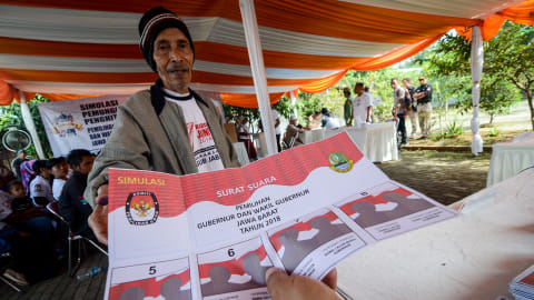 Warga mengambil surat suara saat melakukan simulasi pemungutan suara di Desa Tegalluar, Kabupaten Bandung, Jawa Barat, Sabtu (12/5).  Foto: ANTARA FOTO/Raisan Al Farisi