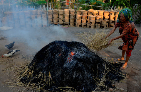 Perajin membakar gerabah dengan jerami di Sentra Gerabah Sandi, Kabupaten Takalar, Sulawesi Selatan. Foto: Abriawan Abhe/Antara Foto
