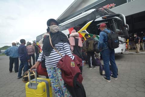 Sejumlah penumpang memindahkan barang-barang mereka ke bagasi bus jurusan Jakarta- Bogor - Bandung, di terminal NPM Padang, Sumatera Barat, Selasa (4/5).  Foto: Iggoy el Fitra/ANTARA FOTO