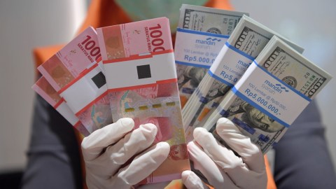 Karyawan menghitung uang rupiah dan dolar AS di Bank Mandiri Syariah, Jakarta, Senin (20/4/2020). Foto: ANTARA FOTO/Nova Wahyudi