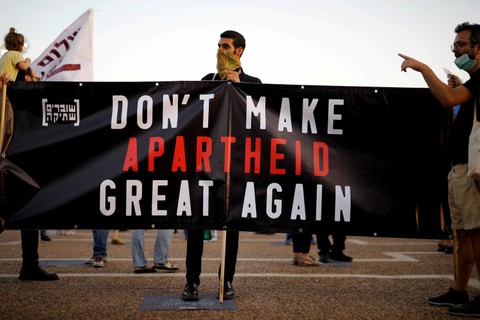 Warga membawa poster saat demo terhadap rencana Perdana Menteri Israel Benjamin Netanyahu yang akan menggambil bagian Tepi Barat Palestina di Tel Aviv, Israel. Foto: REUTERS/Amir Cohen