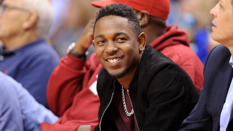 Rapper Kendrick Lamar duduk di tepi lapangan di pertandingan NBA. Foto: AFP/Robyn Beck