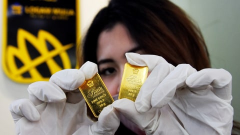 Karyawan menunjukan emas batangan yang dijual di Butik Emas Antam, Kebon Sirih, Jakarta. Foto: Indrianto Eko Suwarso/ANTARA FOTO