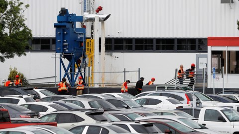 Seorang pekerja melintas di pabrik Tesla di Fremont, California, AS, Selasa (12/5/2020). Foto: Reuters/Stephen Lam