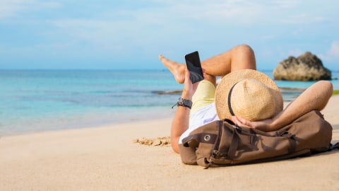 Ilustrasi menggunakan gadget saat traveling. Foto: Getty Images
