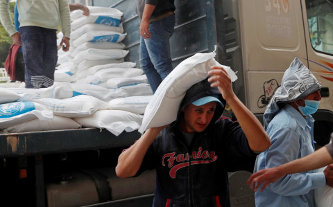Petugas mendistribusikan bantuan makanan dari PBB untuk warga di Sheikh Redwan, Gaza, Palestina, Selasa (31/3). Foto: AP Photo/Adel Hana