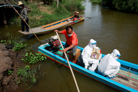 Petugas kesehatan Thailand melakukan perjalanan menggunakan perahu untuk melakukan tes swab kepada warga yang tinggal di komunitas terpencil di Samut Prakan, Thailand.  Foto: Soe Zeya Tun/REUTERS
