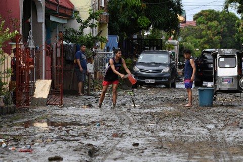 Foto: Warga Bersihkan Lumpur usai Badai Tropis Naglae Menerjang Filipina