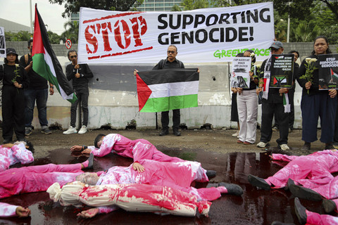 Foto: Aktivis Tunjukkan Poster 'Stop War Peace Now' di Depan Kedubes AS