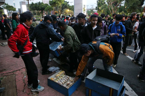 Foto: Di Tengah Demo Ricuh di Senayan, Pedagang Roti Bagikan Dagangannya