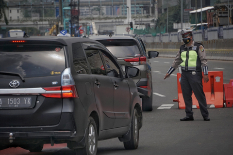 Polisi mengarahkan mobil ber-pelat akhir angka genap pada titik ganjil-genap M.H Thamrin di Bundaran Patung Kuda dekat Monas, Rabu (1/9/2021). Foto: Jamal Ramadhan/kumparan