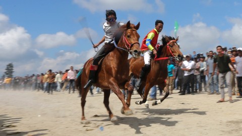 Sejumlah Joki memacu kuda lokal gayo pada lomba pacuan kuda tradisional di lapangan pacuan kuda Sengeda, Bener Meriah, Aceh, Sabtu (25/12/2021). Foto: Irwansyah Putra/ANTARA FOTO