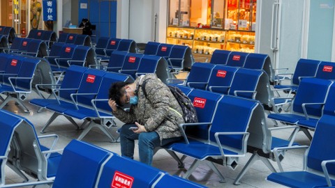Seorang pelancong menunggu untuk naik keretanya di stasiun Kereta Api Selatan Beijing menjelang perayaan Tahun Baru Imlek, di Beijing, China, Rabu (10/2). Foto: Thomas Peter/REUTERS