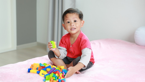 Ilustrasi anak balita bermain balok sambil duduk di dalam rumah. Foto: Shutter Stock