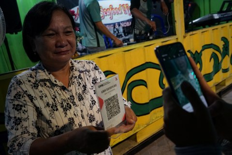Konsumen membayar non tunai dengan menggunakan Quick Response Indonesia Standard (QRIS) di Palangkaraya, Kalimantan Tengah, Senin (16/3). Foto: ANTARA FOTO/Makna Zaezar