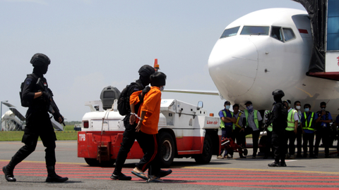 Personel Densus 88 Anti Teror membawa terduga teroris menuju ke pesawat udara di Bandara Internasional Juanda, Sidoarjo, Jawa Timur, Kamis (18/3/2021). Foto: Umarul Faruq/ANTARA FOTO