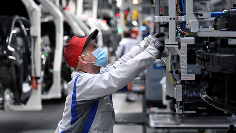 Sebastian Lohse mengenakan masker saat bekerja di lini produksi untuk model Volkswagen ID.3 listrik di Zwickau, Jerman. Foto: Hendrik Schmidt/Pool via REUTERS